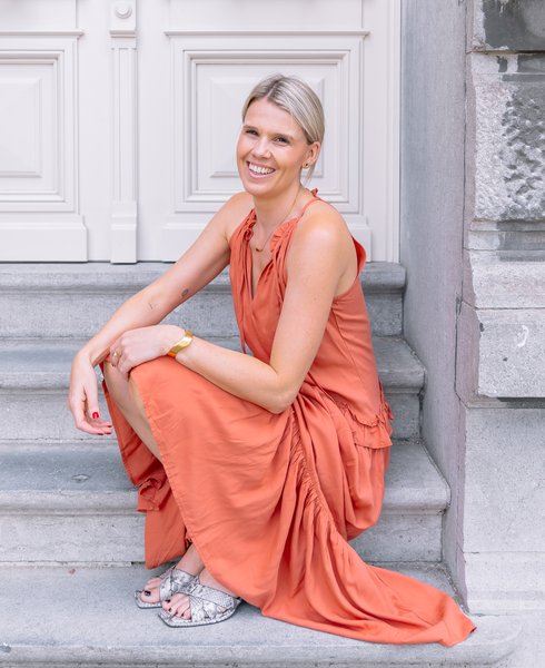 Sarah op de trappen in Antwerpen, in haar terracotta jurk